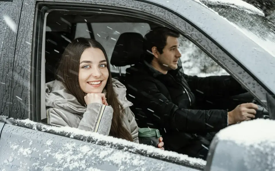 casal a andar num carro coberto de neve
